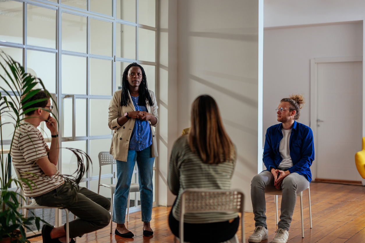 African woman talking in group therapy The Benefits of Our Peer Support Program
