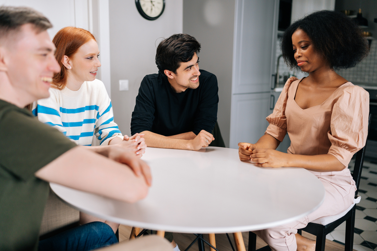 Cheerful multiethnic young friends gathered together, laughing at funny joke sitting at circle table in living room. Portrait of multicultural people having fun The Science Behind Our Half-Day Treatment Program